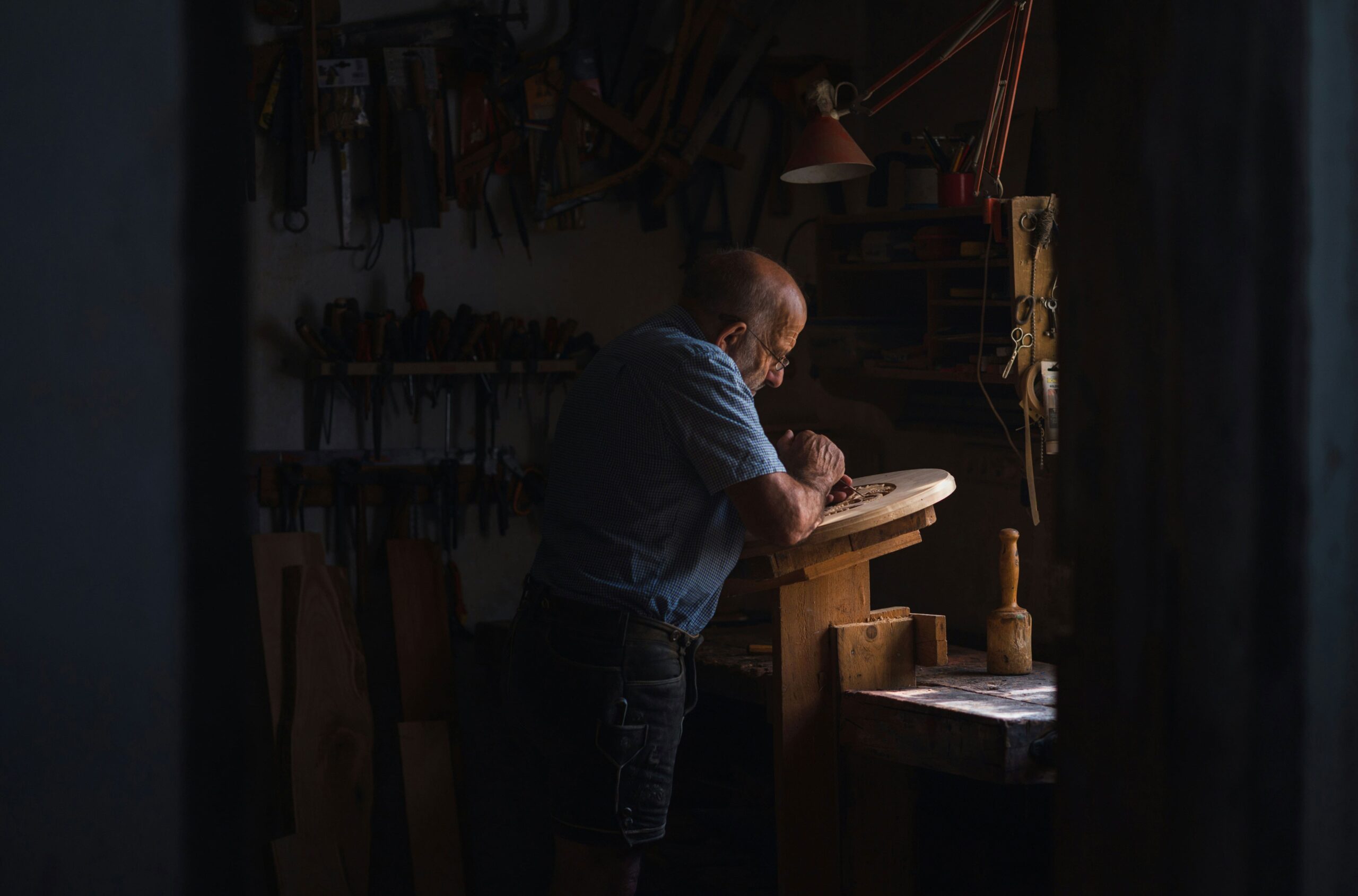 Man working on wooden table design in workshop alex gruber unsplash