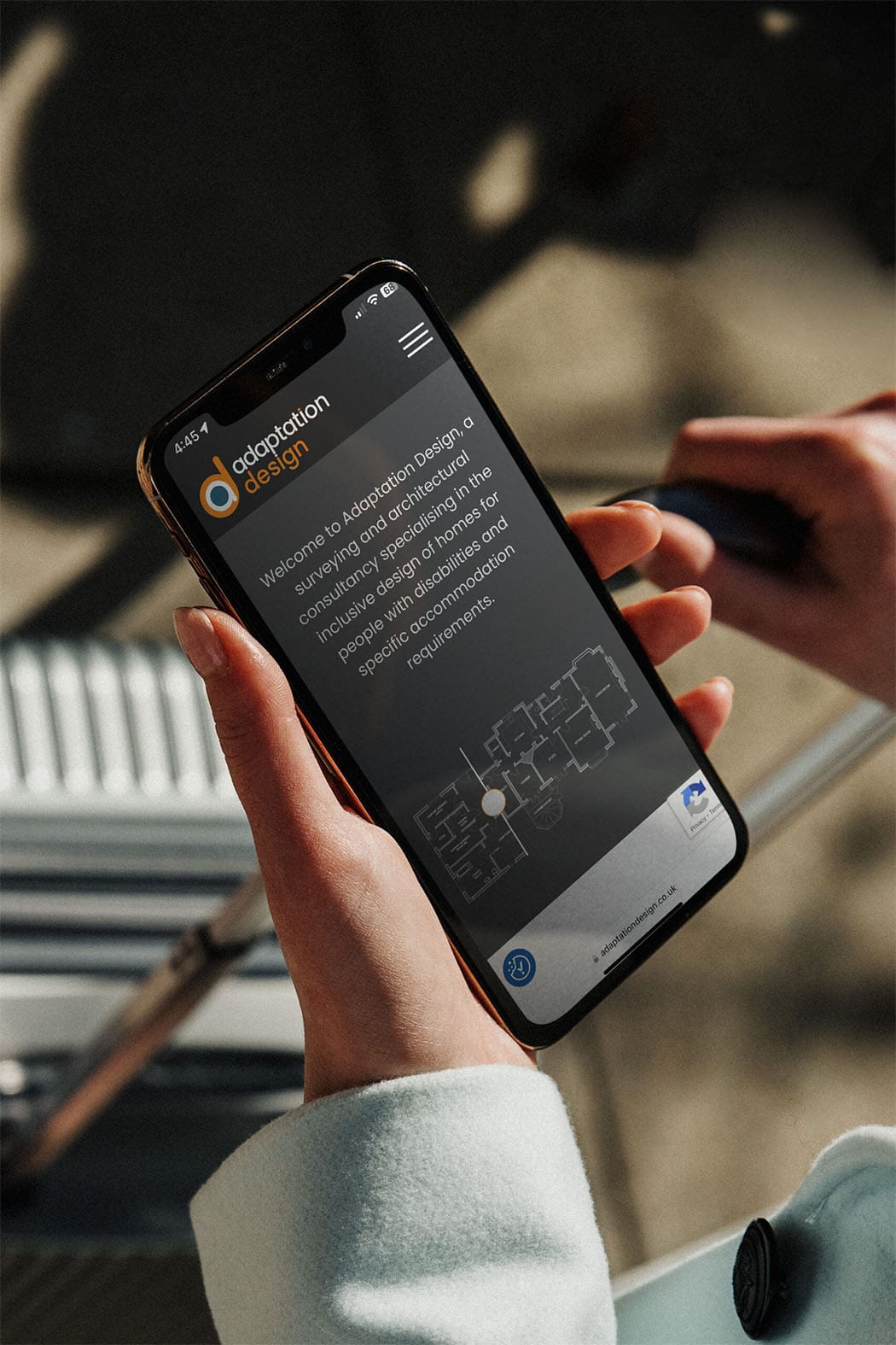Adaptation Design website on a mobile held by a woman in airport