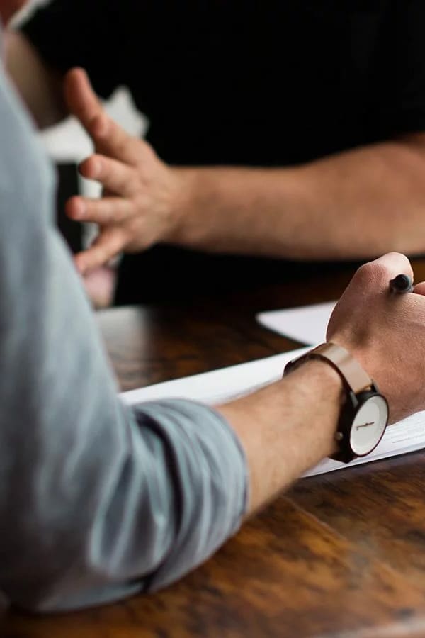 Two people discuss marketing and make notes