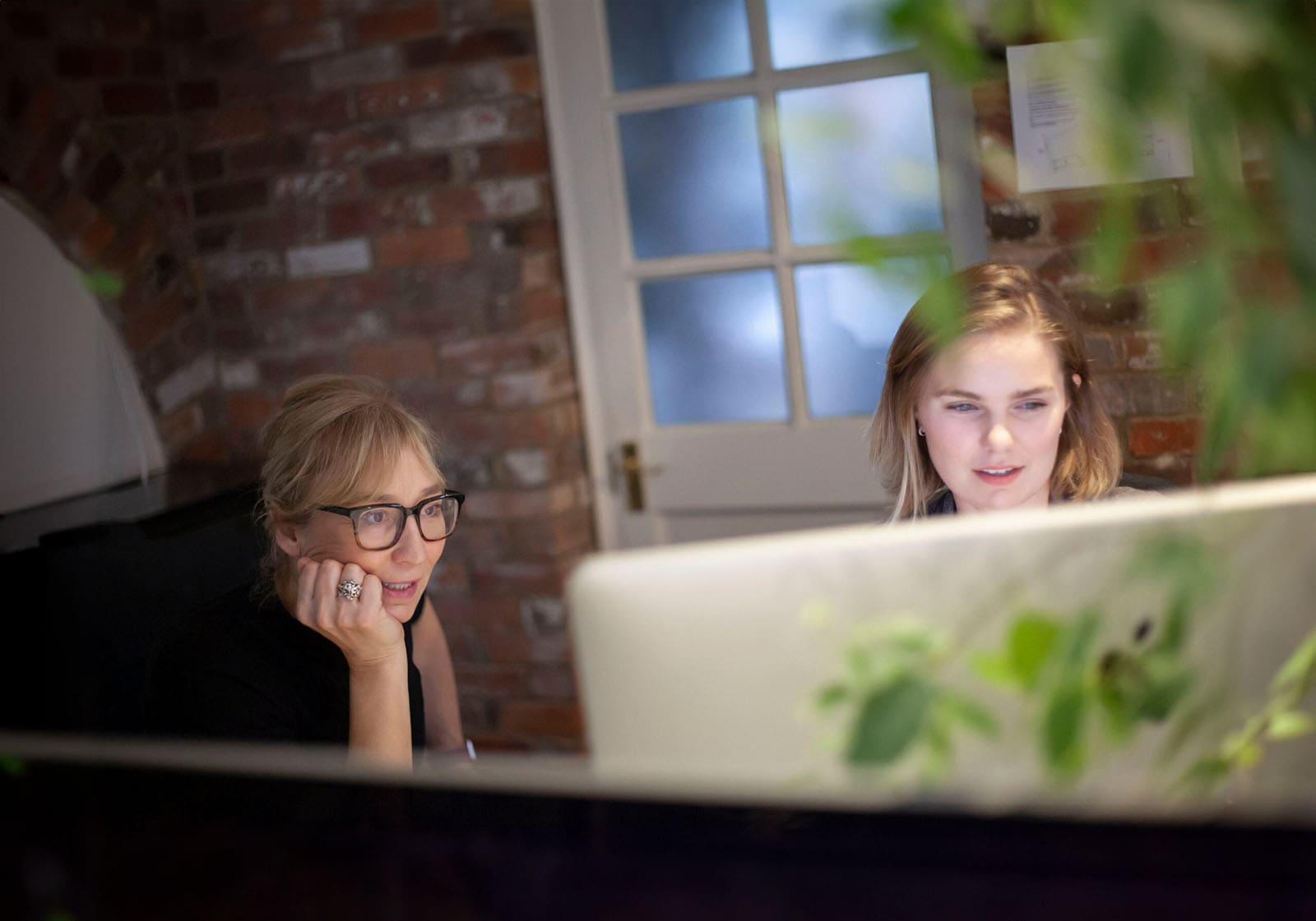 designers discussing work in front of imac