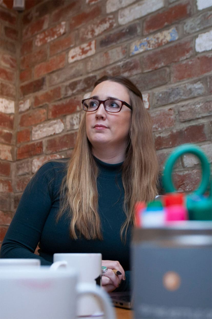 Row sits in a marketing meeting in the Resolution office.