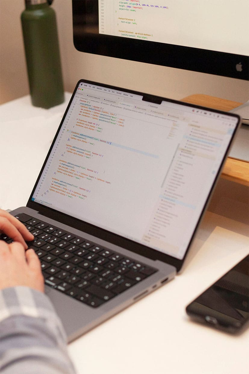 person typing on laptop with code on the screen